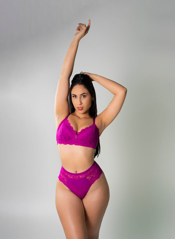 pexels-photo-29819356 Stylish pose of a woman in pink lingerie against a neutral background.